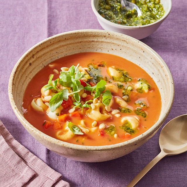 Italiaanse tomatensoep met tortellini, pesto en basilicum